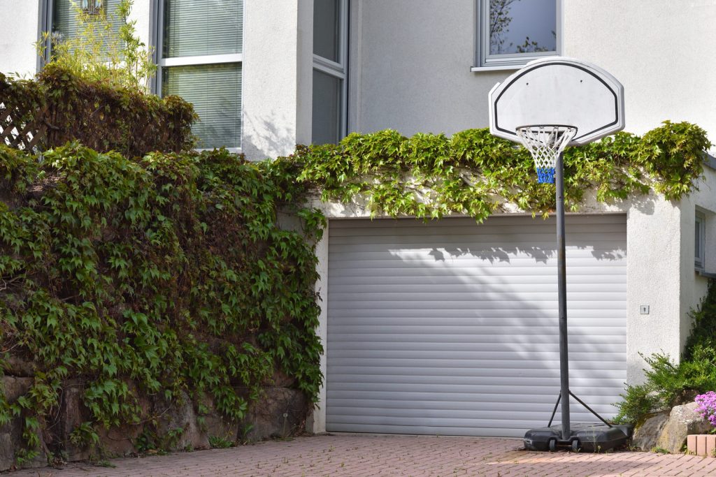 Panier de basket devant une porte de garage close